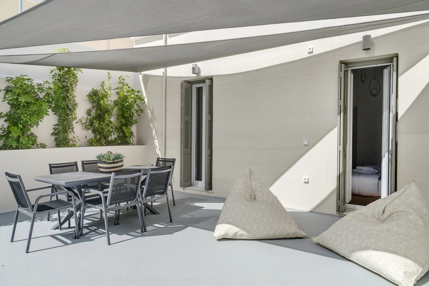 Lower terrace shared by bedrooms one and two, with a table and planted surroundings