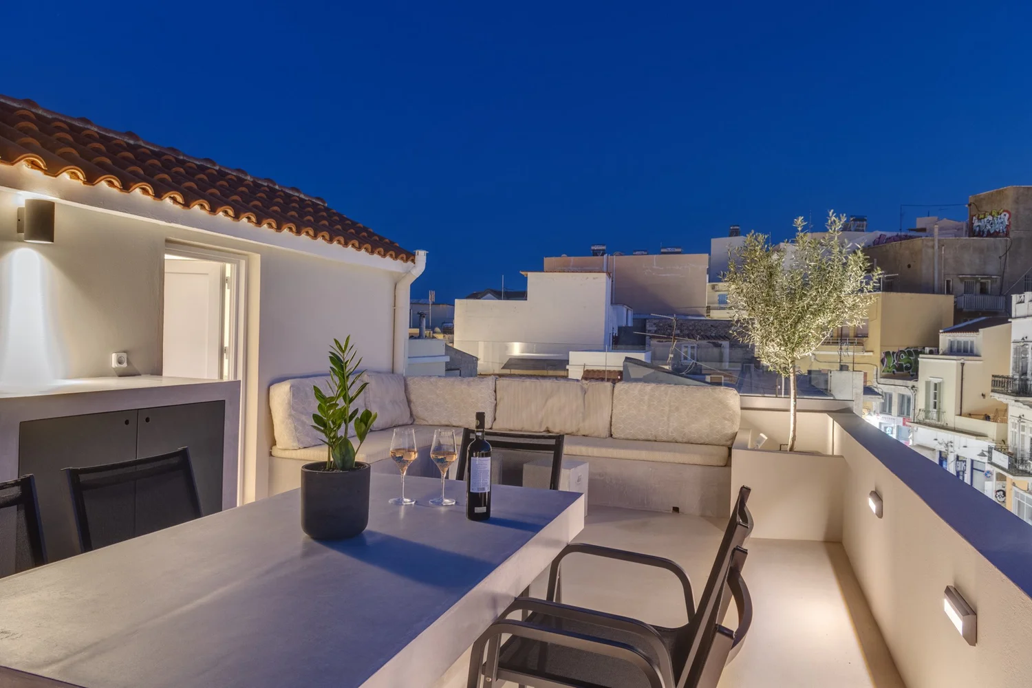 Upper terrace set for an evening meal, overlooking Ermoupolis